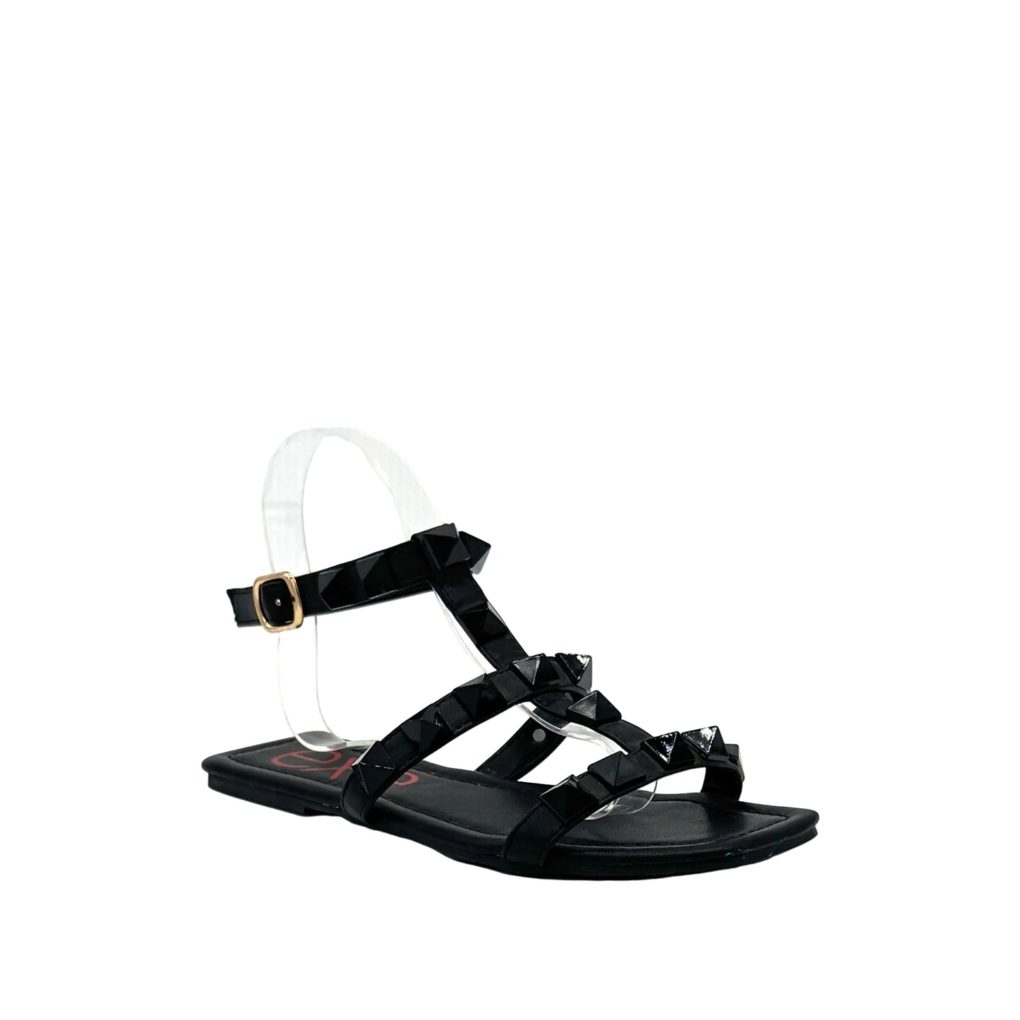 Black: EXE 2269-2781 pyramid stud T-strap flat sandal in black with gold-tone ankle buckle and square toe, side view