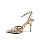 EXE Joy-959 crystal-embellished caged heel sandal in gold with rhinestone lattice straps, ankle strap buckle, and jeweled sculptural heel, side view
