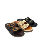 Three women's slide sandals with braided jute trim and large decorative oval buckle details, shown on a white background. The sandals are in black, tan, and dark brown.