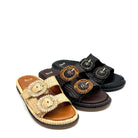 Two decorative slide sandals on a plain white background, one in natural woven straw with large round woven and bead-embellished straps, and one in black woven material with dark brown straps and matching embellishments.