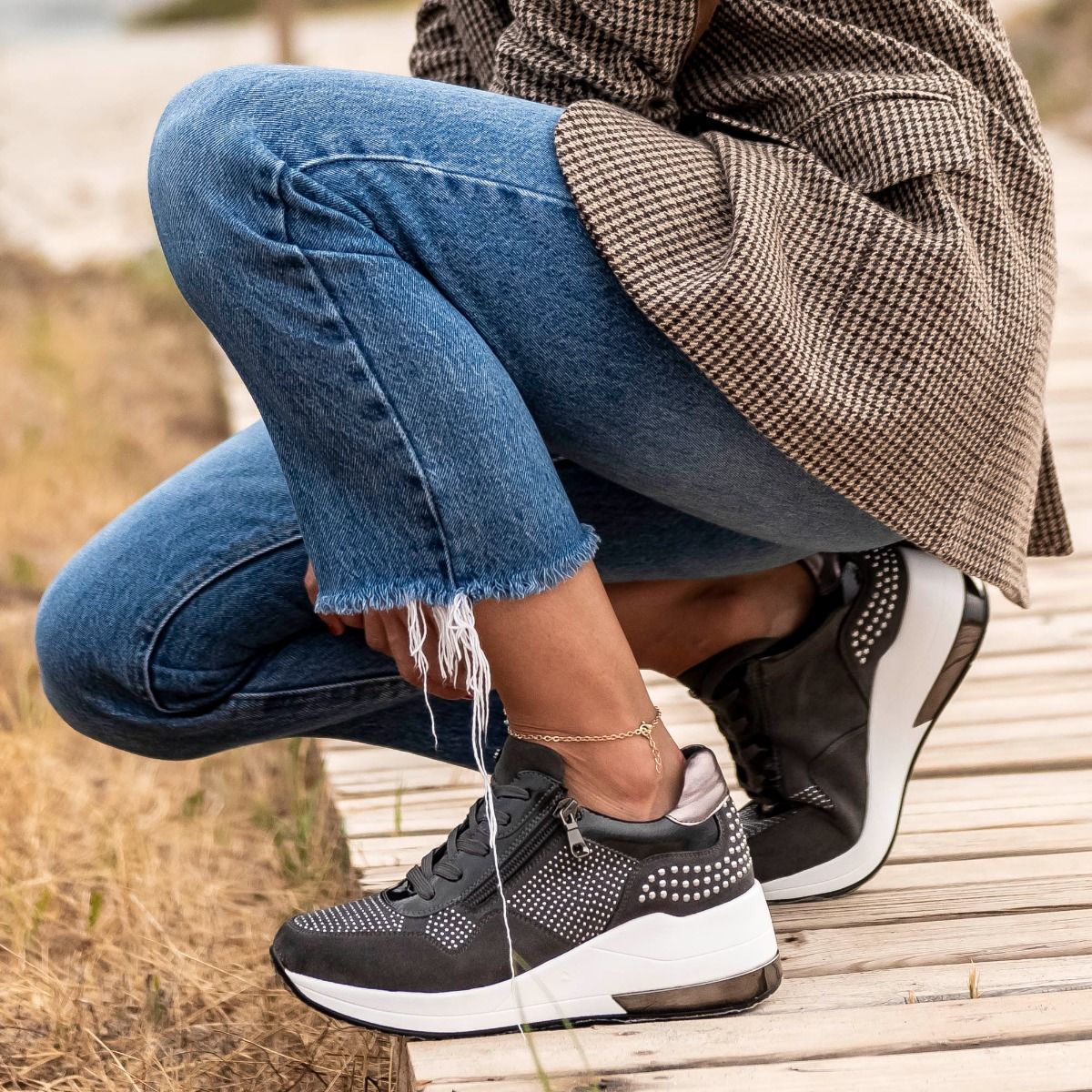 Renato Garini EX34 grey embellished wedge sneakers styled with cropped blue jeans and a checked jacket, worn outdoors