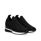 Pair of Renato Garini WEX22 black rhinestone slip-on wedge sneakers at a three-quarter angle, showing rounded toes and contrasting white sole trim